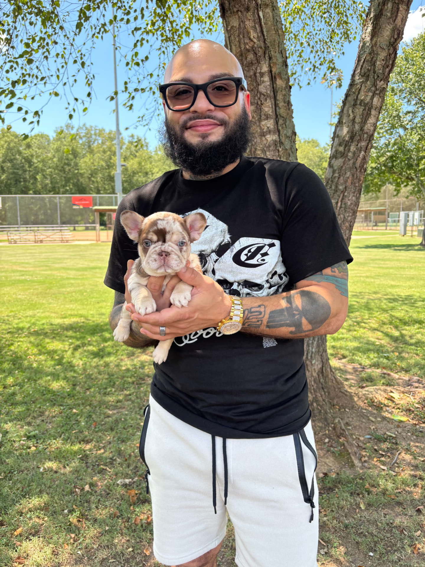 Carlos with a merle French Bulldog puppy at the park